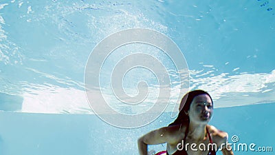 Underwater swimmer in a blue pool.