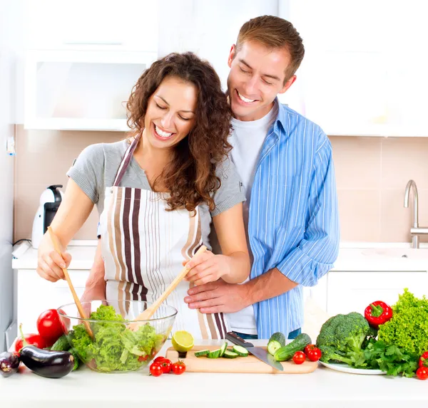Happy couple cooking together in kitchen.
